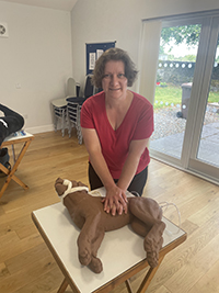 Janice performing CPR on a dummy dog